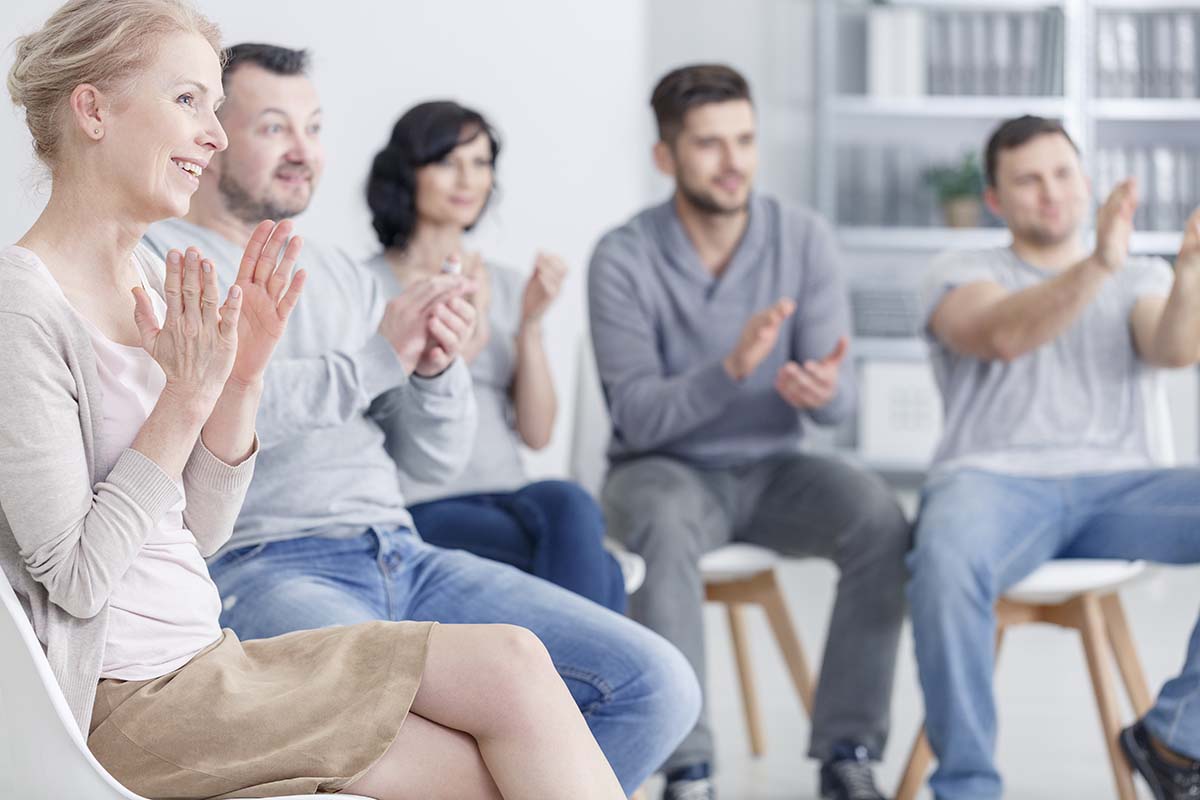 therapy circle clapping at drug addiction rehabilitation