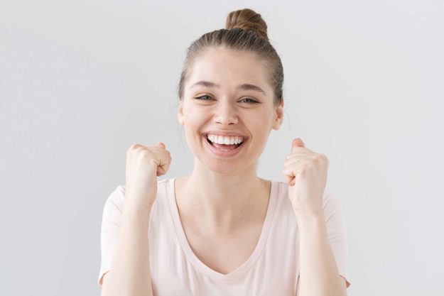 woman smiling with her fists up because she knows how to fight addiction