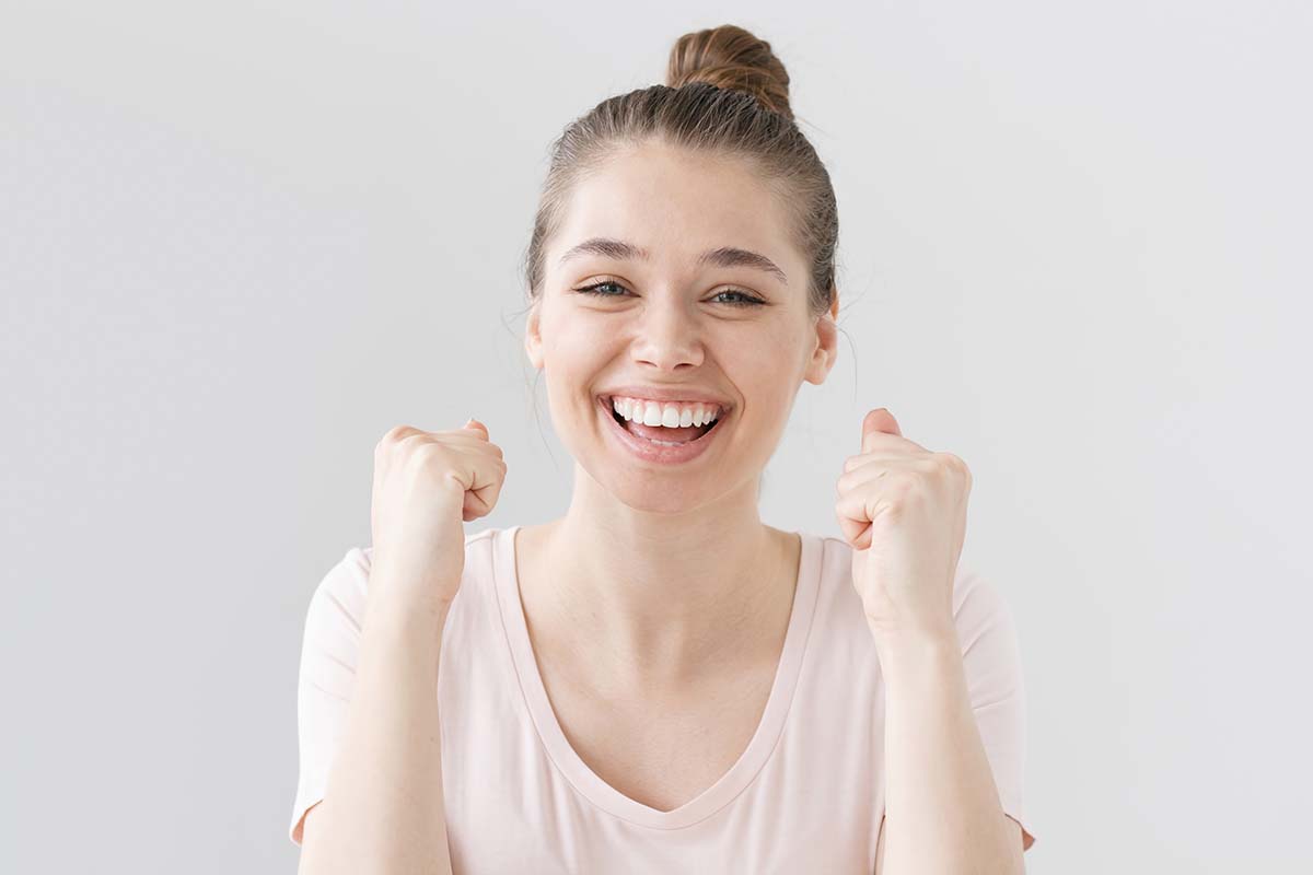 woman smiling with her fists up because she knows how to fight addiction