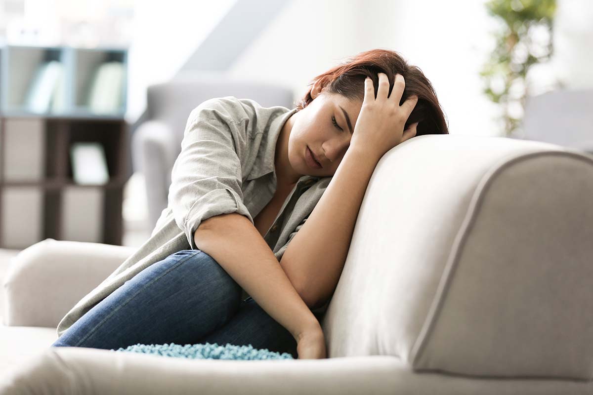 woman leaning on couch after having taken prescription opioids
