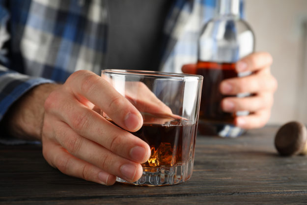 man is blase to risks of alcohol abuse as he drinks more liquor