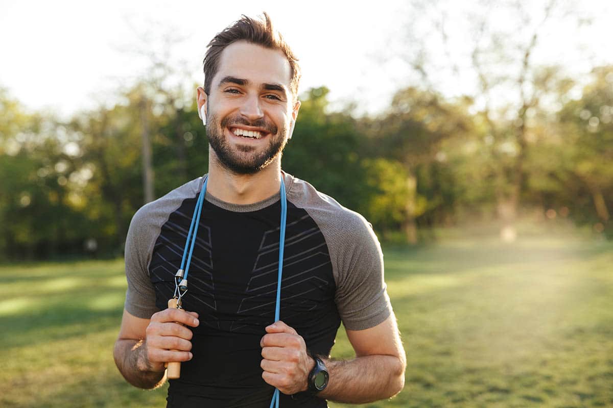 man in field smiling looking athletic giving Tips For Relapse Prevention
