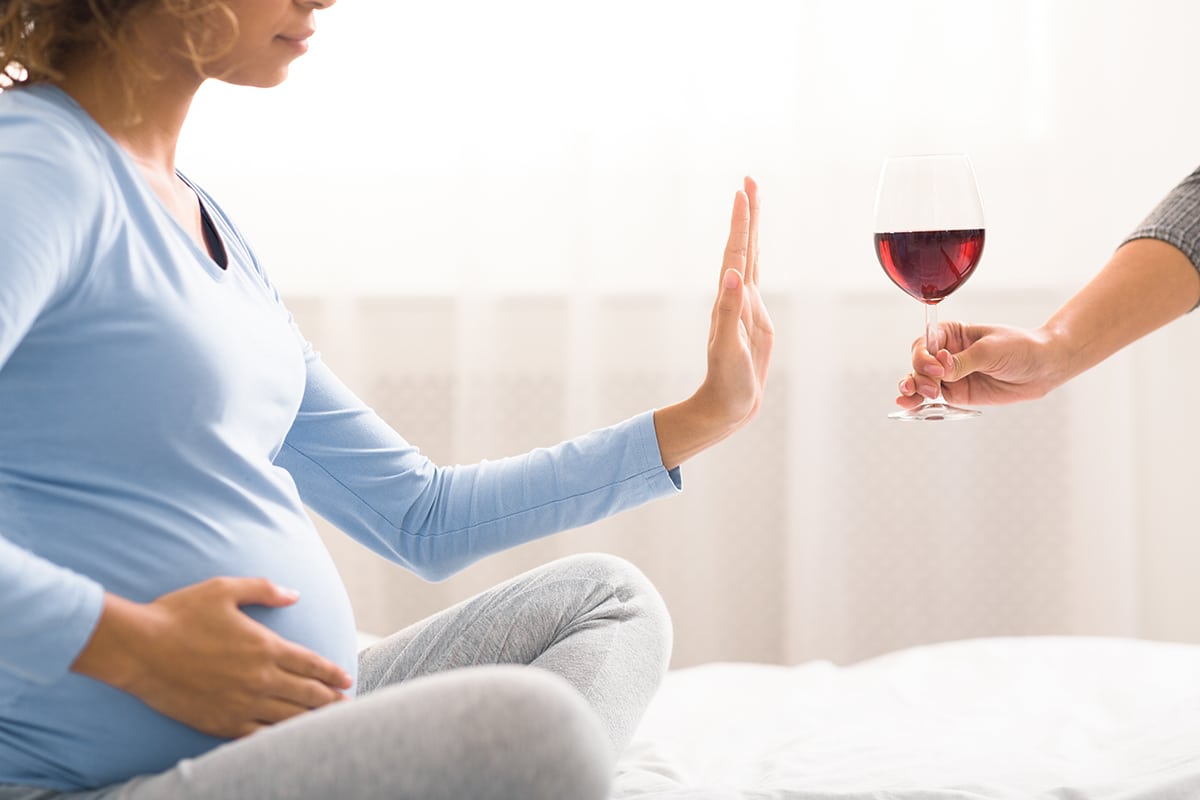 women denying a glass of wine to prevent fetal alcohol syndrome