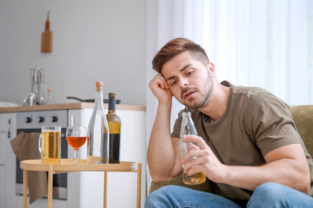 man drinking alone showing drug and alcohol abuse
