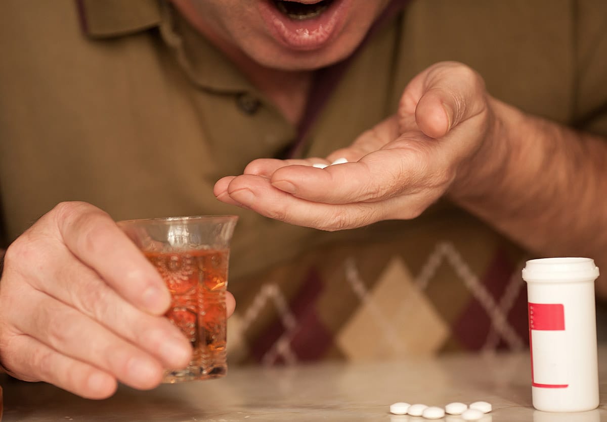 individual mixing alcohol and pills showing painkiller addiction signs
