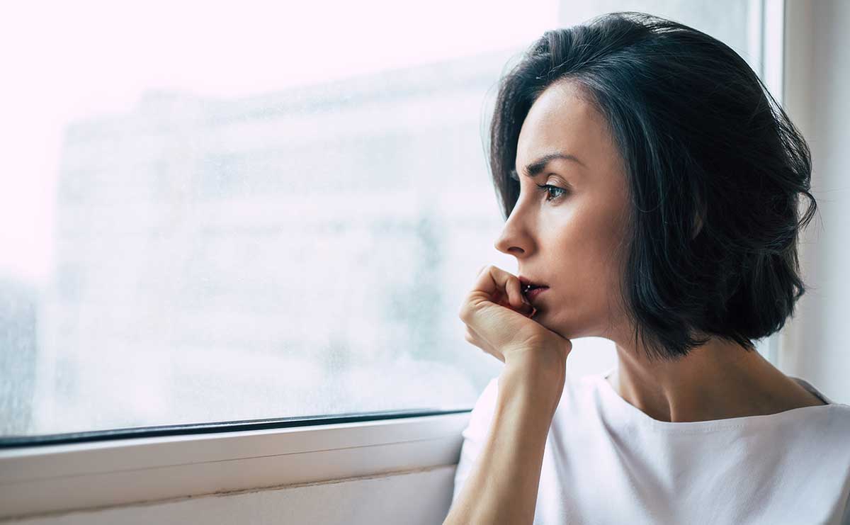 woman looking out window thinking about co-occurring disorders