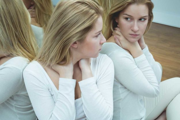 woman looking into mirrors dealing with bipolar disorder
