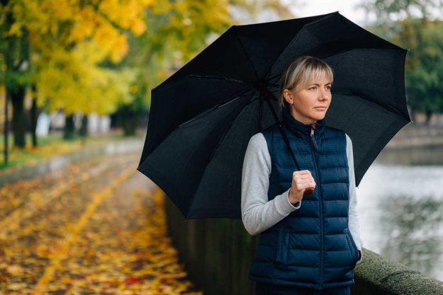 woman outside in rain dealing with seasonal depression