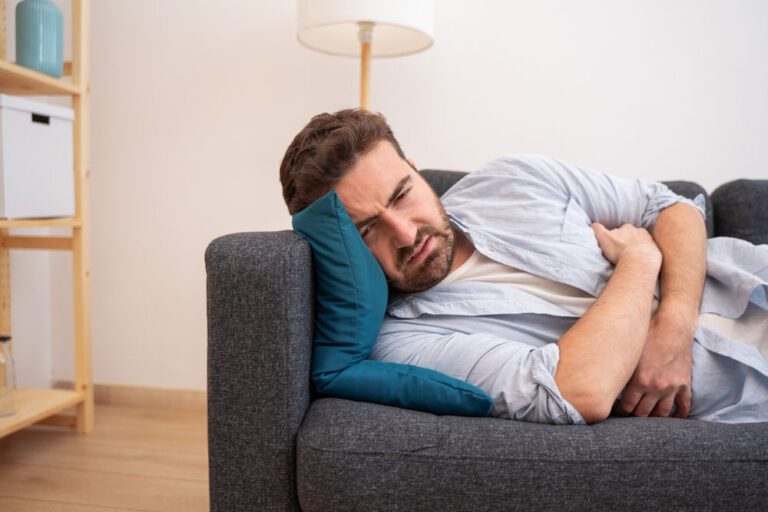 man suffering from alcohol bloating wondering how long it will last