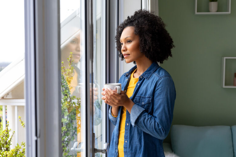 girl holding a mug by the window reflecting on echoism, opposite of a narcissist