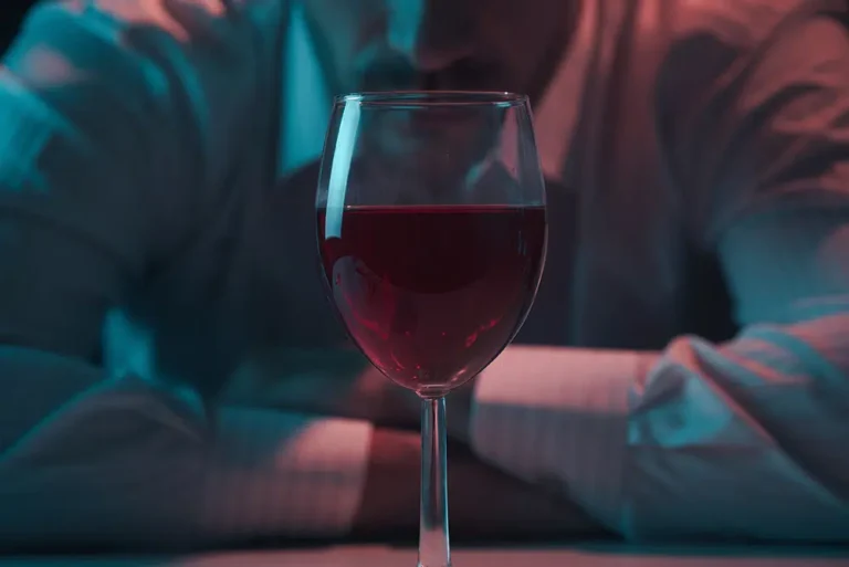 guy holding a glass of alcohol considering the risks of mixing zyrtec and alcohol