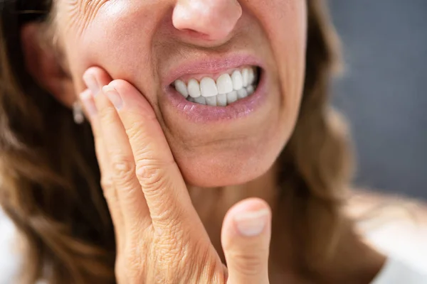 Woman experiencing tooth ache or discomfort caused by drug use