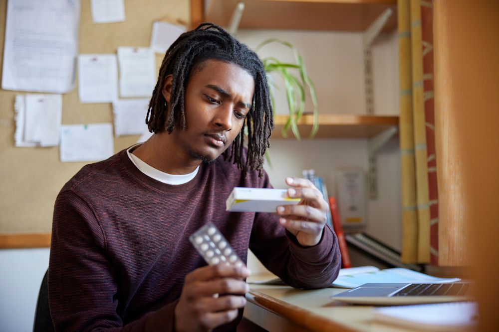 a man reading the box of a medicine