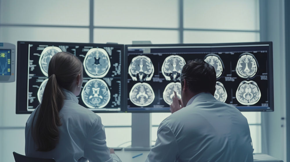 Doctors reviewing brain scan images while discussing neurodivergent symptoms and neurological patterns during a clinical evaluation.