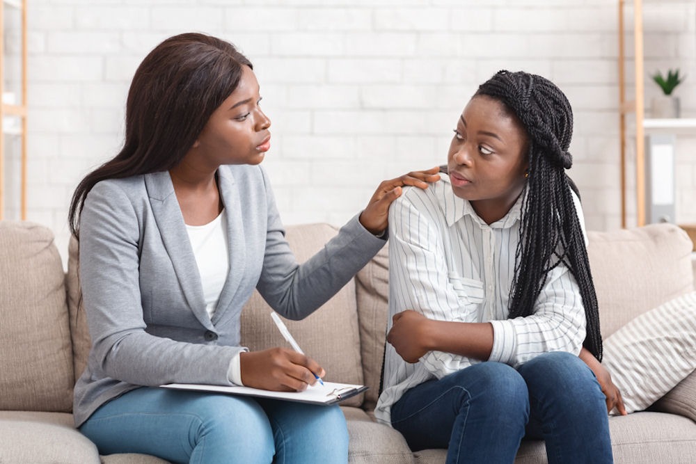 Therapist comforting a young woman during a teen mental health counseling session
