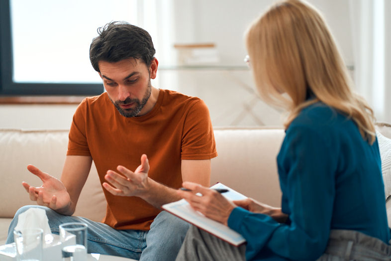 tricare-insurance-for-veterans-therapy-session Man speaking with a therapist about treatment options and Tricare Insurance for Veterans.