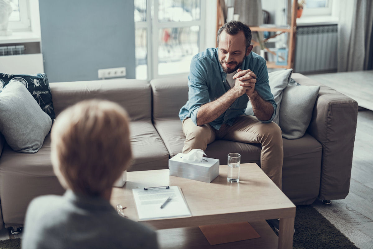 tricare-insurance-for-veterans-treatment-options Man meeting with a therapist to discuss care covered by Tricare Insurance for Veterans.